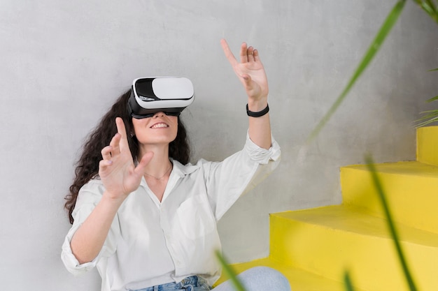 Foto gratuita mujer joven que usa un tiro medio del casco de realidad virtual