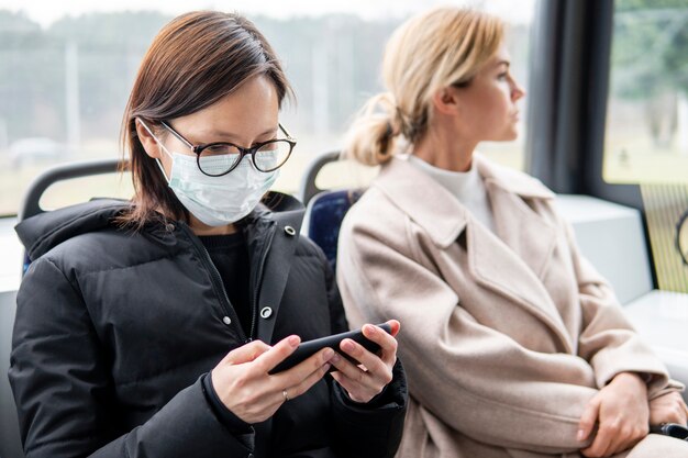 Mujer joven que viaja con mascarilla quirúrgica