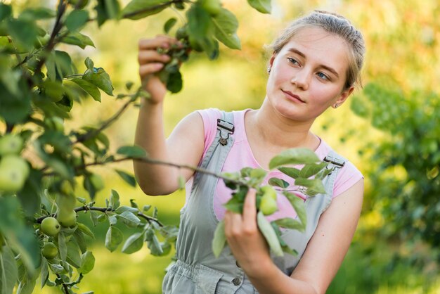 Mujer joven con ramas de los árboles