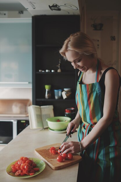 Mujer joven, rebanar, tomates