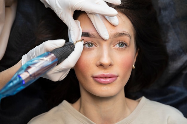 Mujer joven recibiendo un tratamiento de belleza para sus cejas