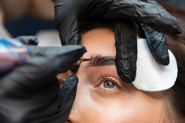 Mujer joven recibiendo un tratamiento de belleza para sus cejas