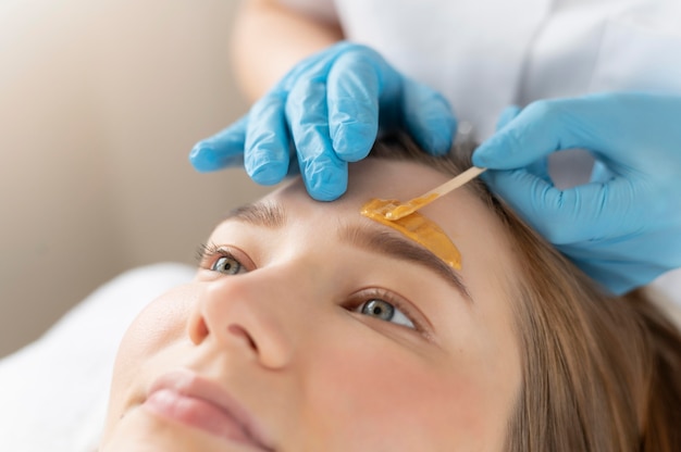 Foto gratuita mujer joven recibiendo un tratamiento de cejas en el salón de belleza