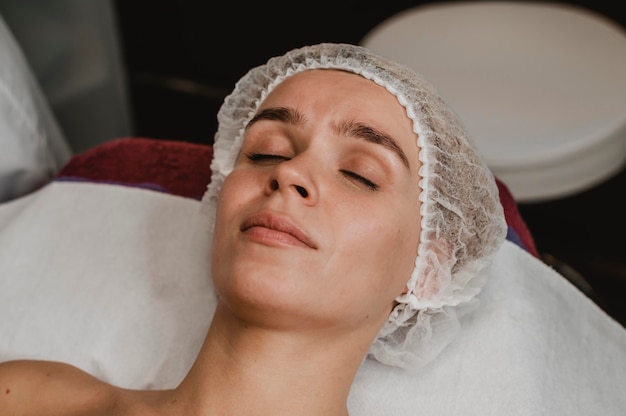 Mujer joven recibiendo un tratamiento cosmético en el spa