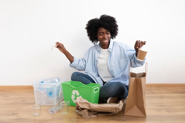 Foto gratuita mujer joven reciclando por un mejor medio ambiente