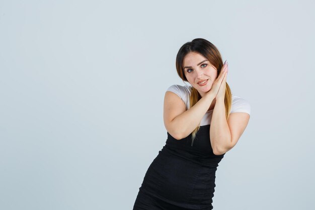 Mujer joven, reclinado, mejilla, en, palmas, y, mirar, lindo