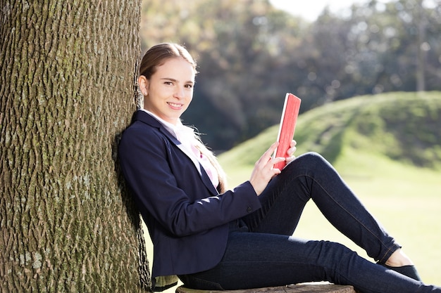 Mujer joven relajada usando su tableta al aire libre