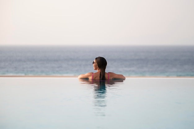 Mujer joven, relajante, solo, en la piscina