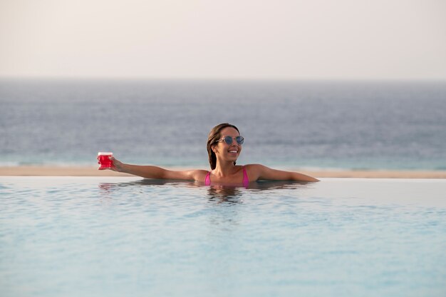 Mujer joven, relajante, solo, en la piscina