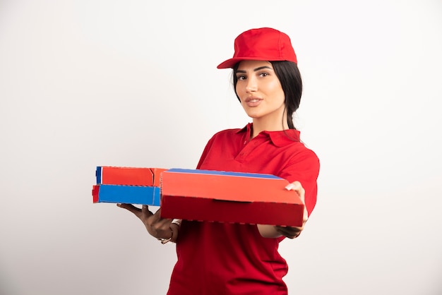 Mujer joven repartidora de pizzas regalando pizza.