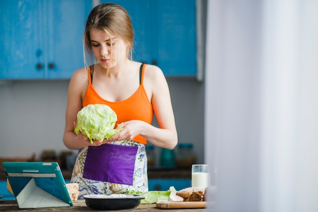 Foto gratuita mujer joven con repollo fresco