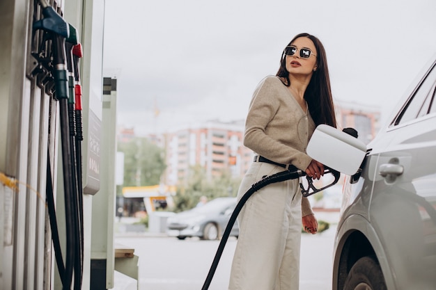 Mujer joven repostando su coche