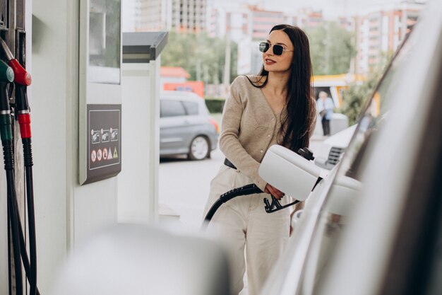 Foto gratuita mujer joven repostando su coche