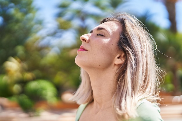 Mujer joven respirando en el parque