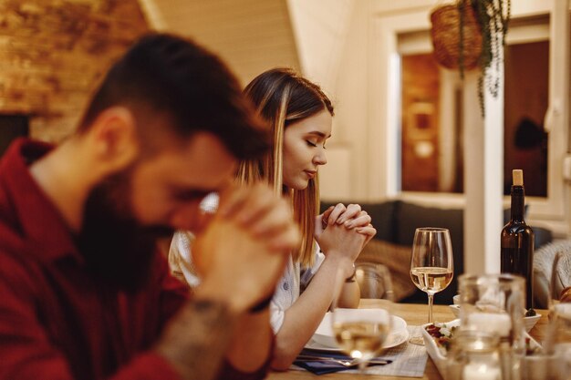 mujer joven, rezando, antes de, un, comida, en, mesa de comedor, foco, es, mujer