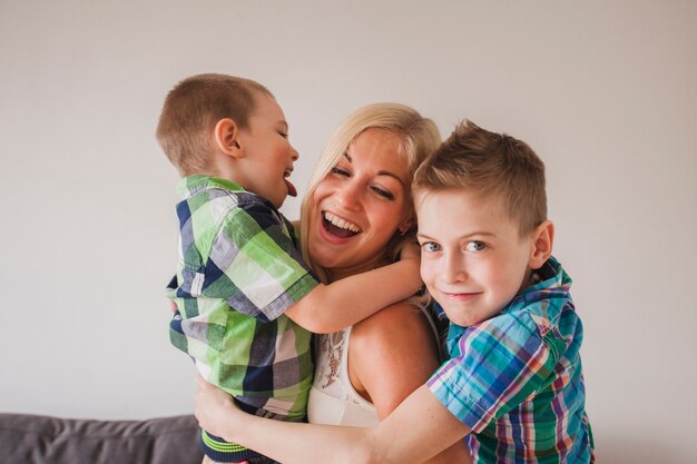 Mujer joven riendo con sus hijos