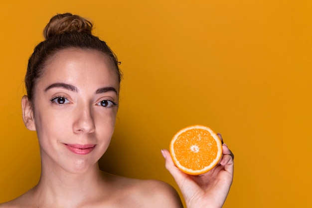 Foto gratuita mujer joven con rodaja de naranja