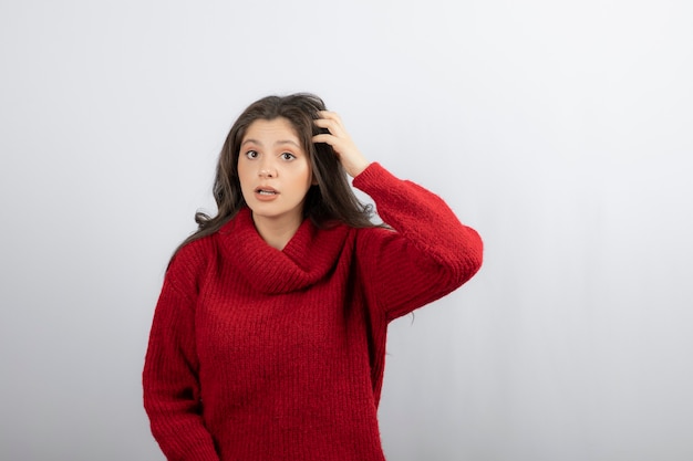 Mujer joven, en, rojo, caliente, tenencia, cabeza