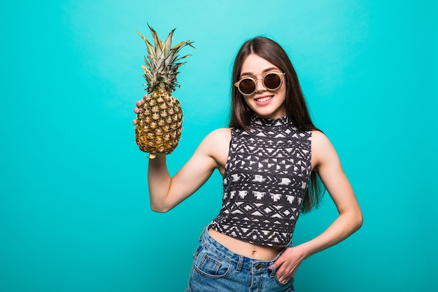 Mujer joven en ropa casual con gafas de sol withp con piña en manos aisladas