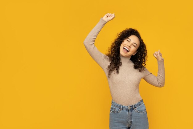 Mujer joven en ropa casual sobre fondo amarillo