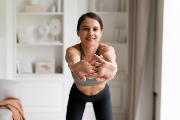 Foto gratuita mujer joven en ropa deportiva haciendo ejercicio en casa