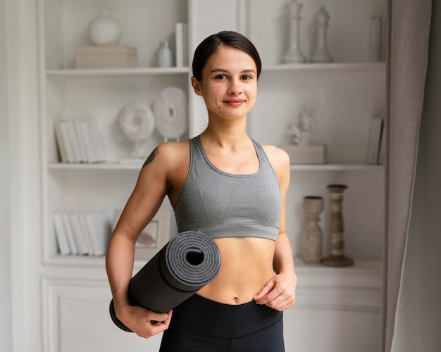 Mujer joven en ropa deportiva haciendo ejercicio en casa