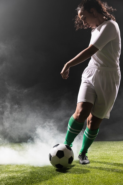 Mujer joven en ropa deportiva jugando al fútbol