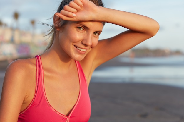 Foto gratuita mujer joven en ropa deportiva en la playa