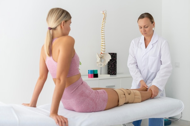 Mujer joven en ropa deportiva practicando un ejercicio en una sesión de fisioterapia