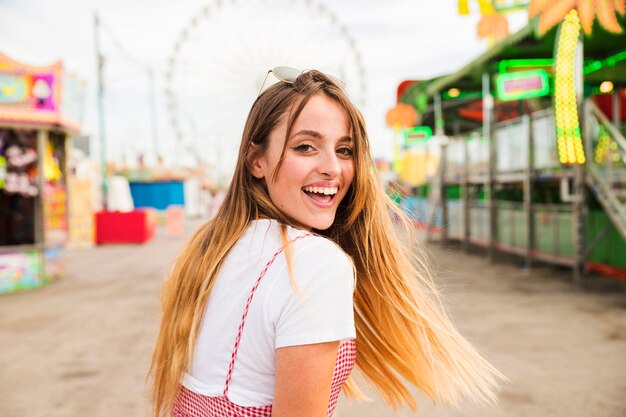 Mujer joven rubia feliz en el parque de atracciones