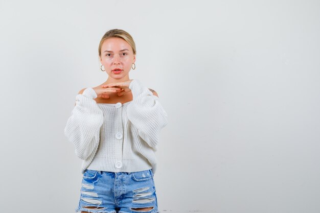 Mujer joven rubia en una rebeca blanca