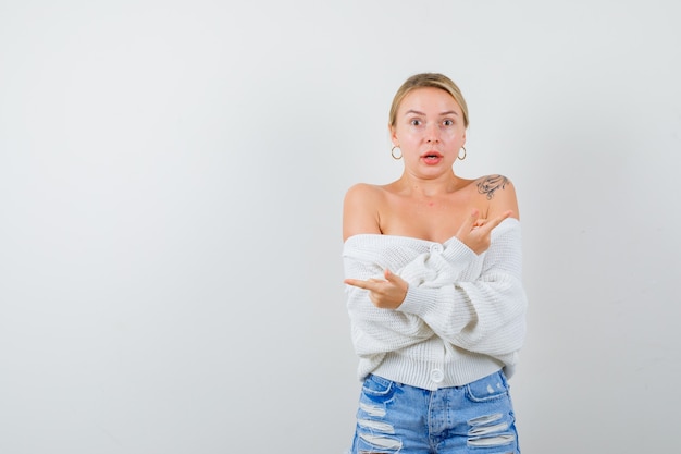 Mujer joven rubia en una rebeca blanca