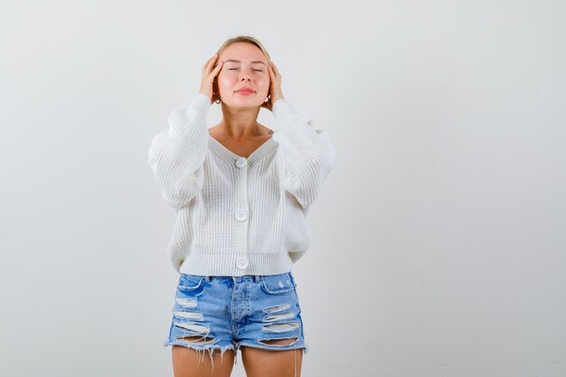 Mujer joven rubia en una rebeca blanca