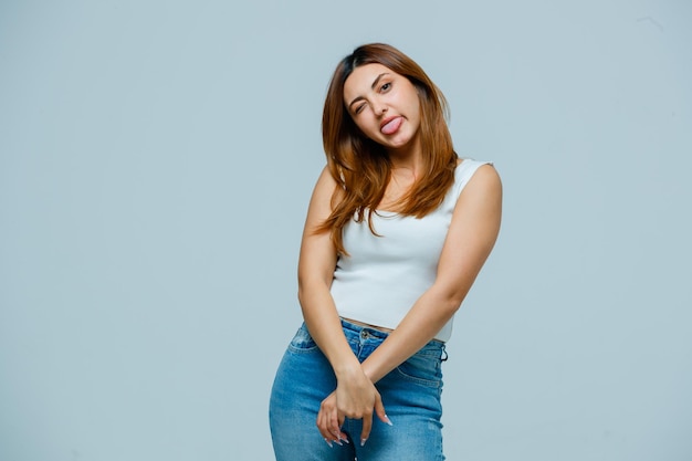 Mujer joven sacando la lengua y mirando gracioso