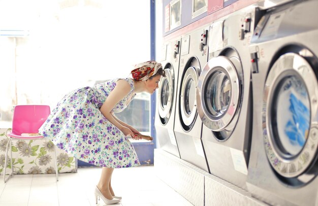 mujer joven en una sala de lavadoras públicas