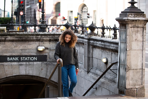 Foto gratuita mujer joven saliendo del metro en la ciudad