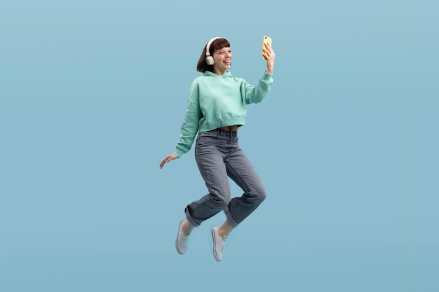 Mujer joven saltando aislado en azul