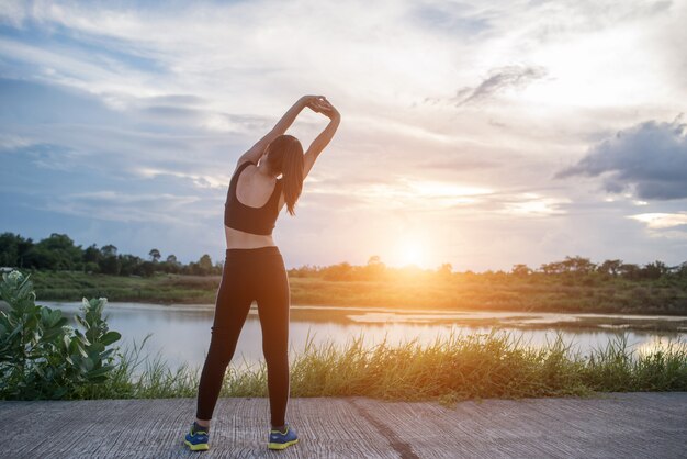 Mujer joven sana calentamiento al aire libre entrenamiento antes de la sesión de entrenamiento en el parque.