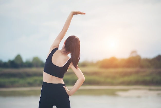 Mujer joven sana calentamiento al aire libre entrenamiento antes de la sesión de entrenamiento en el parque.