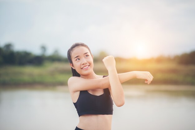 Mujer joven sana calentamiento al aire libre entrenamiento antes de la sesión de entrenamiento en el parque.