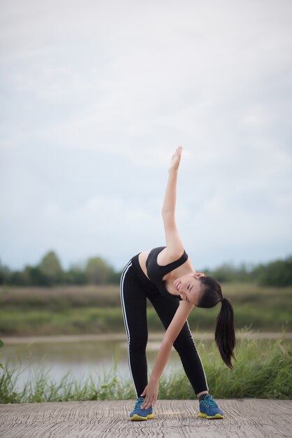 Mujer joven sana calentamiento al aire libre entrenamiento antes de la sesión de entrenamiento en el parque.