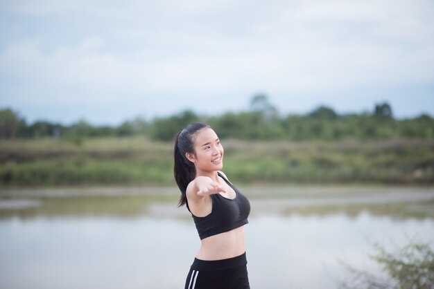 Mujer joven sana calentamiento al aire libre entrenamiento antes de la sesión de entrenamiento en el parque.