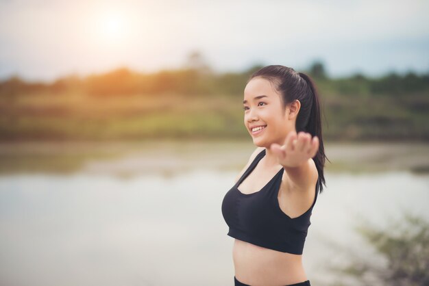 Mujer joven sana calentamiento al aire libre entrenamiento antes de la sesión de entrenamiento en el parque.