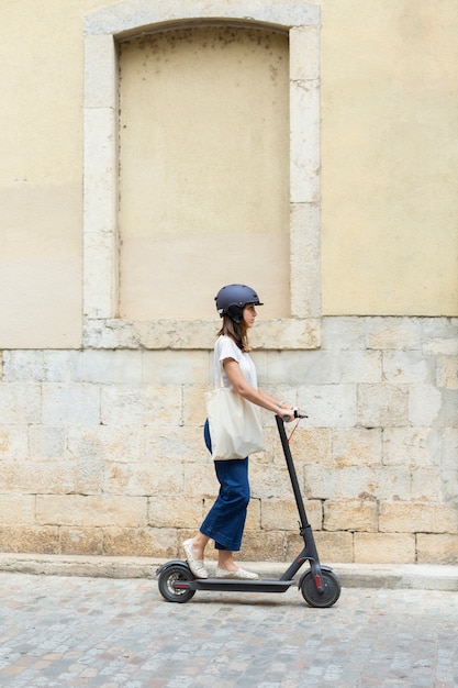 Mujer joven con un scooter ecológico