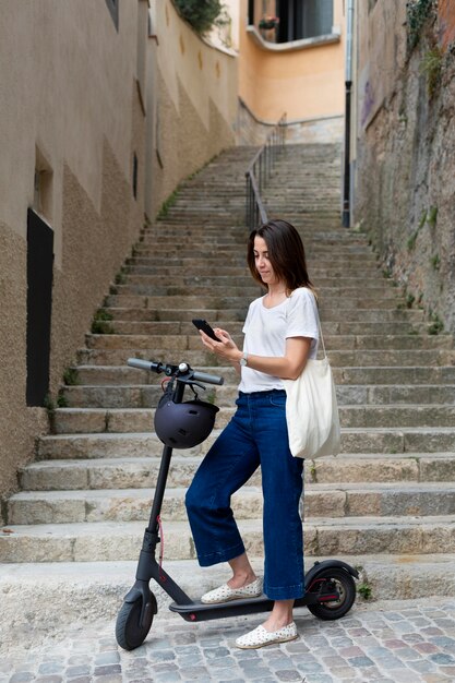 Foto gratuita mujer joven con un scooter ecológico