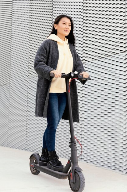 Mujer joven con scooter eléctrico