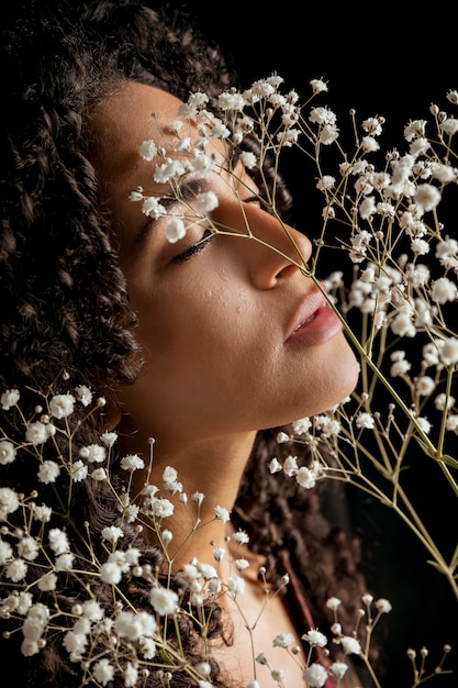 Foto gratuita mujer joven seductora con ramitas florales.