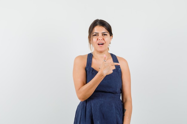 Mujer joven, señalar con el dedo, en, vestido