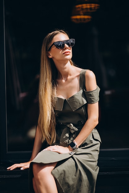 Mujer joven sentada afuera del café