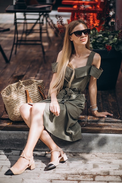 Mujer joven sentada afuera del café